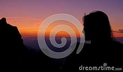 CLOSE UP: Young female hiker observes the Julian Alps from mountaintop at sunset Stock Photo