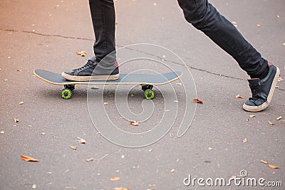 Close-up of a skateboarder`s foot in black sneakers. Stock Photo