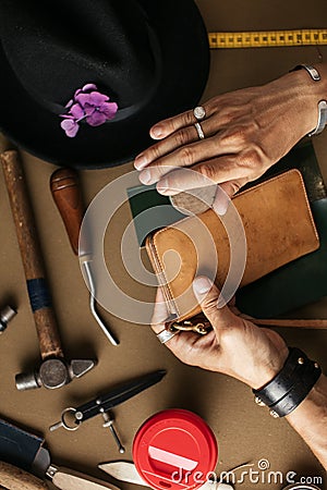 Close up of skinner craftsman working with natural leather using craft tools. Stock Photo