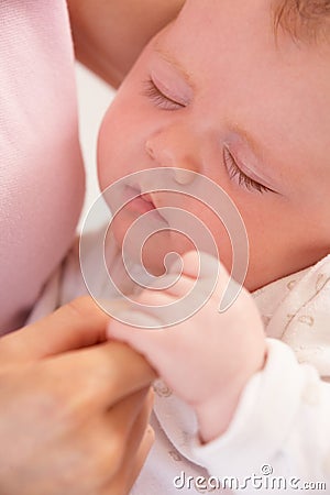 Close Up Of Sleeping Baby Boy Holding Mothers Hand Stock Photo