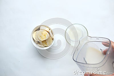 top view of slice of banana and glass of milk on table Stock Photo