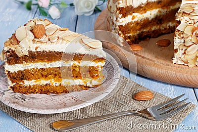 Close-up the slice of carrot cake with almonds on a saucer. Stock Photo