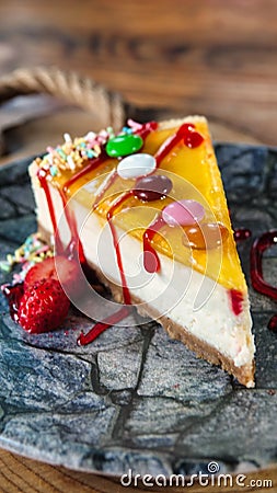Candy coated lemon cheesecake on wooden table Stock Photo