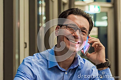 Close up of smiling businessman using modern smart phone, Young happy man working at his office and holding cellphone Stock Photo