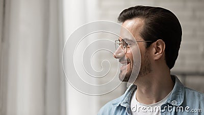 Close up smiling dreamy man wearing glasses looking to aside Stock Photo