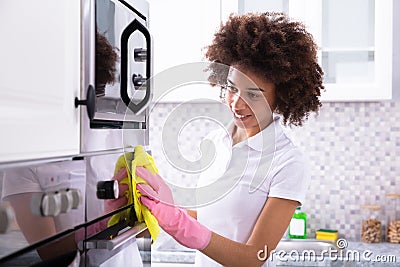 Janitor Cleaning Oven In The Kitchen Stock Photo