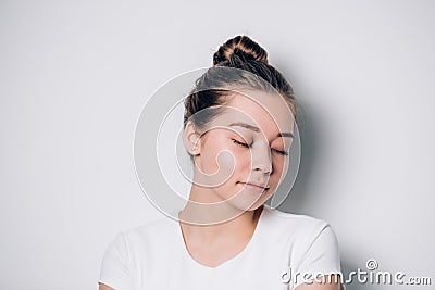 Close up smiling girl in in white t-shirt, eyes closed Stock Photo