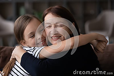 Happy little granddaughter hug elderly granny showing love Stock Photo