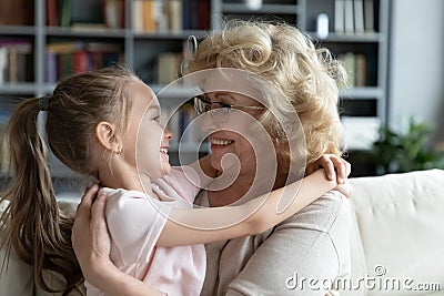 Close up smiling mature grandmother and little granddaughter hugging Stock Photo