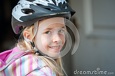 Close up of a smiling young blonde girl in a cycle helmet Stock Photo