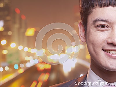 Close-up of smiling young businessman, city lights background Stock Photo