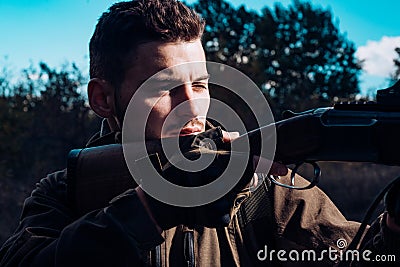 Close up snipers carbine at the outdoor hunting. Close up Portrait of hamdsome Hunter. Hunter with shotgun gun on hunt. Stock Photo