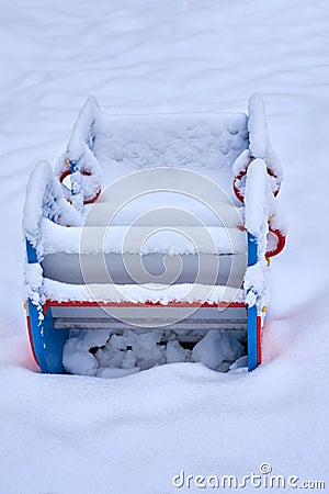 Close up of a snow covered boat shaped seesaw teeter totter in a children play park during the cold winter season Stock Photo
