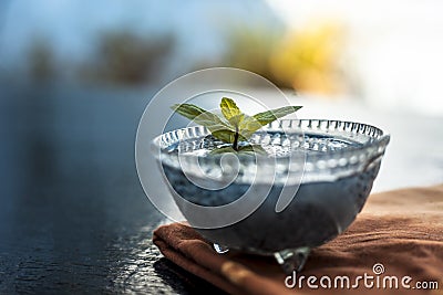 Close up of soaked sabja seeds or falooda seeds or sweet basil seeds in a glass bowl on brown colored napkin on wooden surface wit Stock Photo