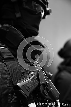 Close up soldier keeping modern gun while wearing bulletproof vest. Uniform concept. Stock Photo