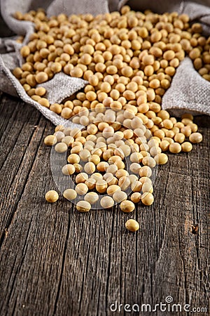 Close-up of soybean on wood background in jute sack. Stock Photo