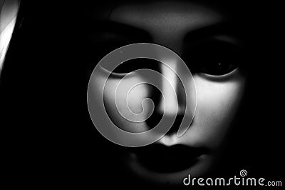 Close up of a spooky looking black eyed child looking directly at viewer, featuring oversized black eyes, pale skin and black hood Stock Photo