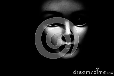 Close up of a spooky looking black eyed child looking passed viewer, featuring oversized black eyes, pale skin and black Stock Photo