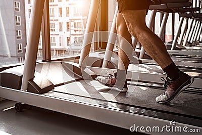 Close up of sport man running on treadmill in fitness gym at condominium in urban. People lifestyles and sport activity concept Stock Photo