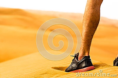 Close-up of sporty man leg/shoe standing alone in the desert. Fitness concept. Stock Photo