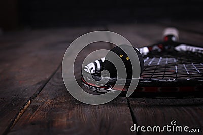 Close up of a squash racket and ball on the wooden background Stock Photo