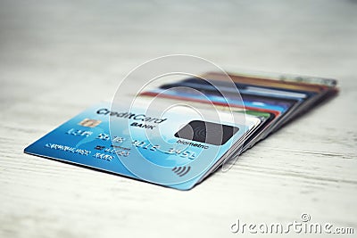 Close up of a stack of credit cards lying in order on the white table top. Many different credit cards with biometric card on top Stock Photo