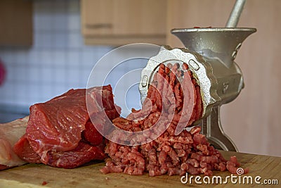 Close up Stainless steel Meat grinder with prepared meat and kitchen Background. Traditional manual meat grinder Stock Photo