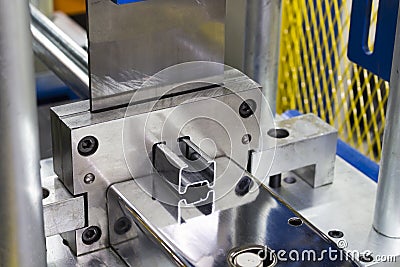 Close up Stainless Steel sheet metal exiting roll forming machine Stock Photo