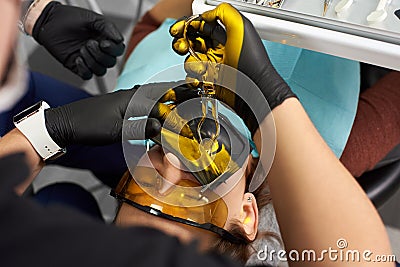 Close-up of stomatologist cures patient with cofferdam and special glasses Stock Photo