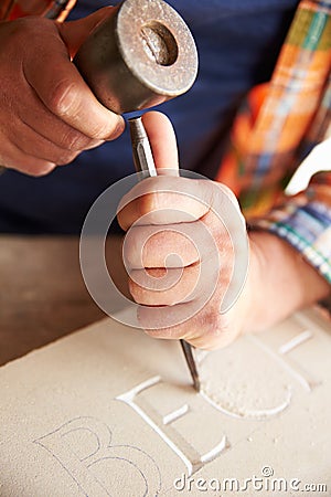 Close Up Of Stone Mason At Work On Carving In Studio Stock Photo