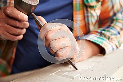 Close Up Of Stone Mason At Work On Carving In Studio Stock Photo