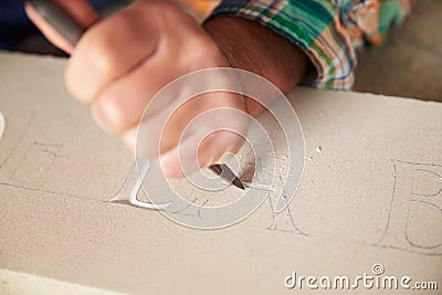 Close Up Of Stone Mason At Work On Carving In Studio Stock Photo