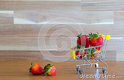 Close up strawberry on shopping cart with white and brown wooden background text advertising, diet food healthy food Stock Photo