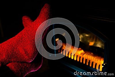 Close up of Stretching Feet in Red Socks by Fireplace Stock Photo