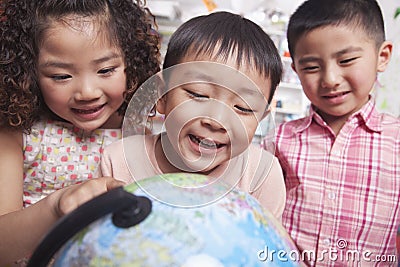Close Up of Students Looking at a Globe Stock Photo