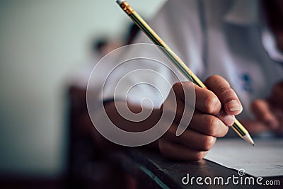 Closeup Students writing and reading exam answer sheets exercises in classroom of school with stress Stock Photo