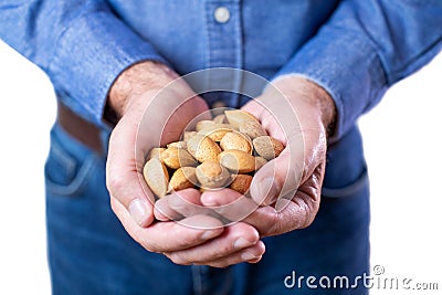 Close Up Studio Shot Of Mature Man Holding Handful Of Almond Nuts In Shells Stock Photo