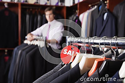 Close-up of suits hanging on rack with price tag in store Stock Photo