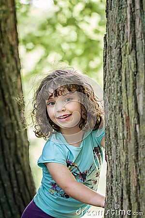 Close up summer portrait of a cute pretty smiling preschool girl with tangled hair. Stock Photo