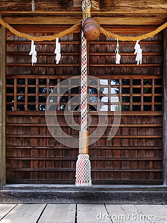 Close-up of Suzu Japanese Shinto bell and the rope hanging under the eaves Stock Photo