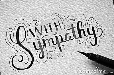 Close-up of `WITH SYMPATHY` hand-lettered on card Stock Photo