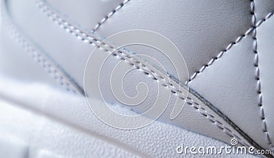 Close-up of synthetic fabric with white diamond stitching and white rubber sole. Sport shoes. Quilted fabric in white or light Stock Photo
