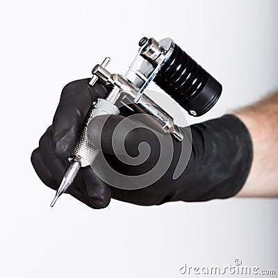Close-up of Tattooist hands in black gloves with tattoo machine Stock Photo