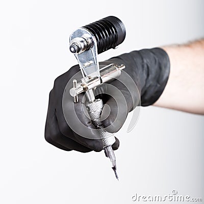 Close-up of Tattooist hands in black gloves with tattoo machine Stock Photo