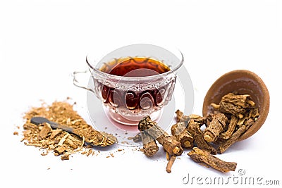 Close up of tea of Indian sarsaparilla or nnanari in a glass cup along with raw sarsaparilla and its powder. Stock Photo