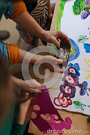 Close-up of teacher showing picture on smartphone to kids during creative art and craft class at school Stock Photo