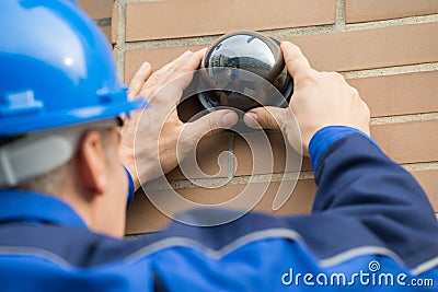 Close-up Of Technician Installing Camera In Building Stock Photo