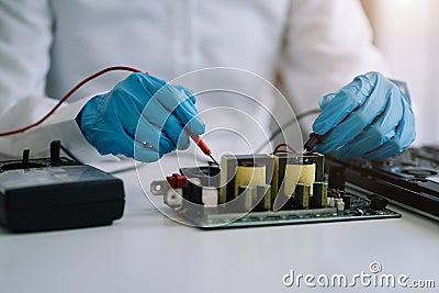 Close up of Technician measuring voltage electronic circuit board, Service after sale fix electric equipment Stock Photo