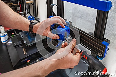 Close-up of technician's hands doing maintenance on 3D printer Stock Photo