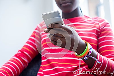 Close Up Of Teenage Girl Wearing Wristbands Using Mobile Phone At Home Stock Photo